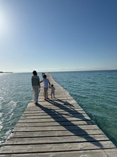 Familj promenerar tillsammans på en lång brygga